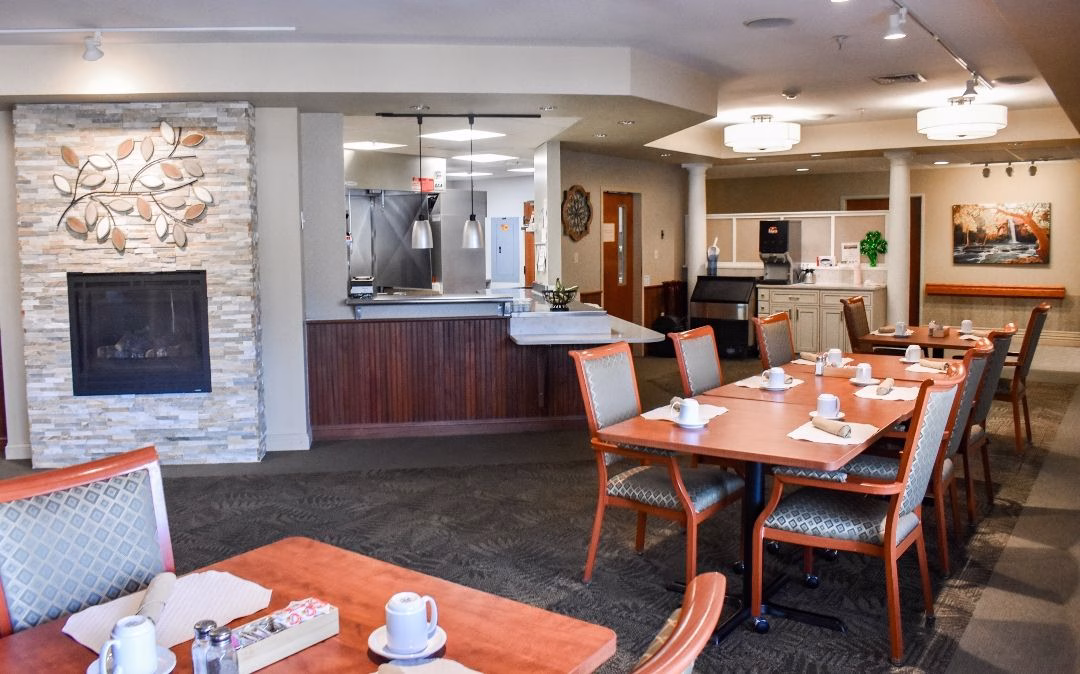 The Grapevine café at Willow Brook Home in Columbus, Ohio, offers a casual dining option with wooden tables, fireplace, and a relaxed atmosphere for residents and guests.